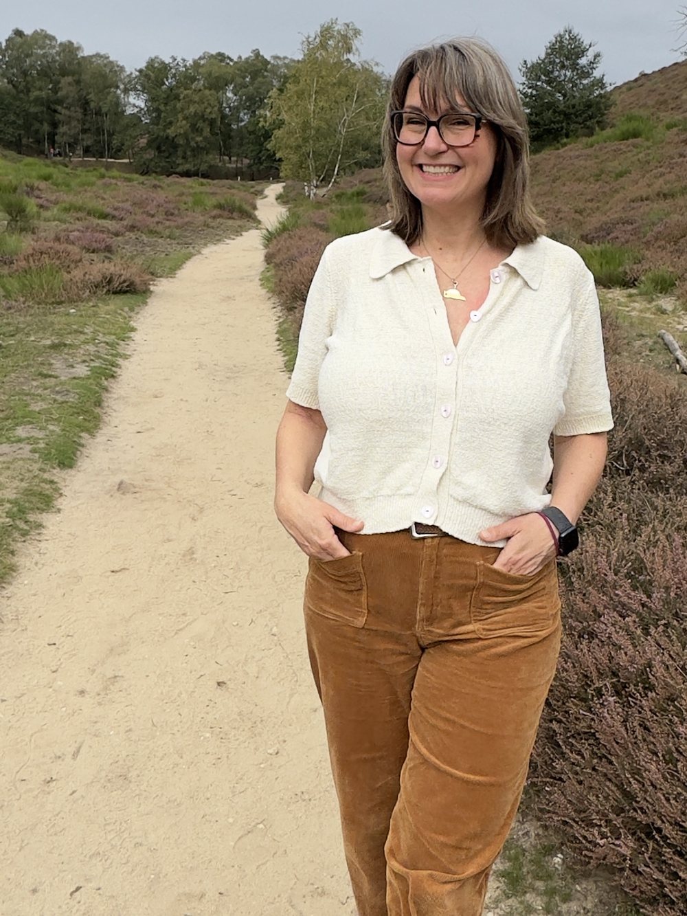Nicole Behnke, lachend op een zandpad over de heide.